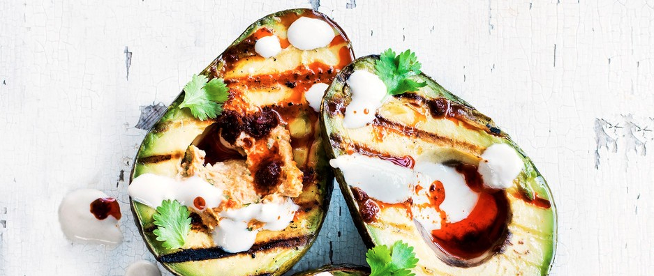 Grilled avocado halves with harissa hummus and tahini yogurt