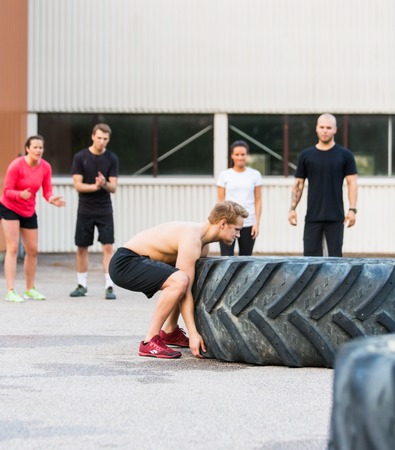 man-flipping-trye-while-friends-motivate-him.jpg